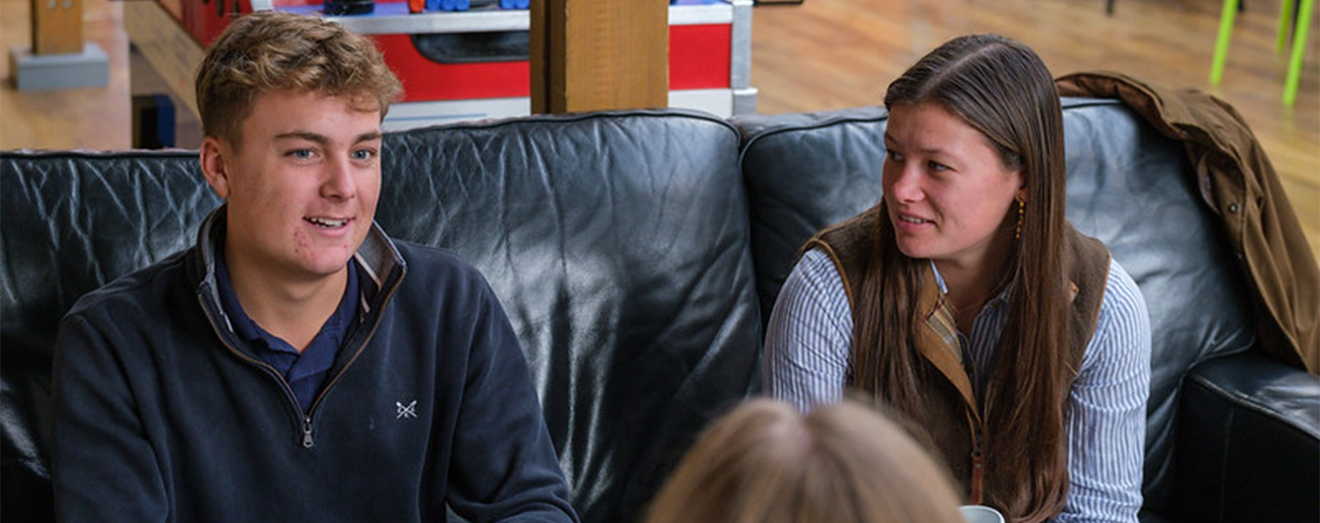 Two students sat on sofa chatting