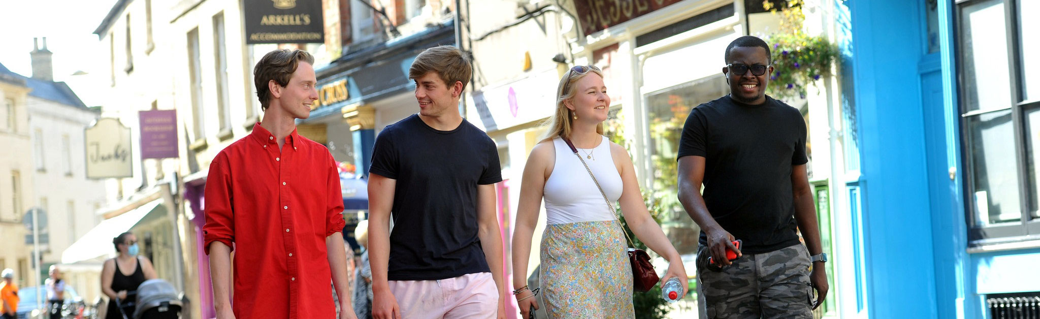 four male and one female student walking through cirencester town