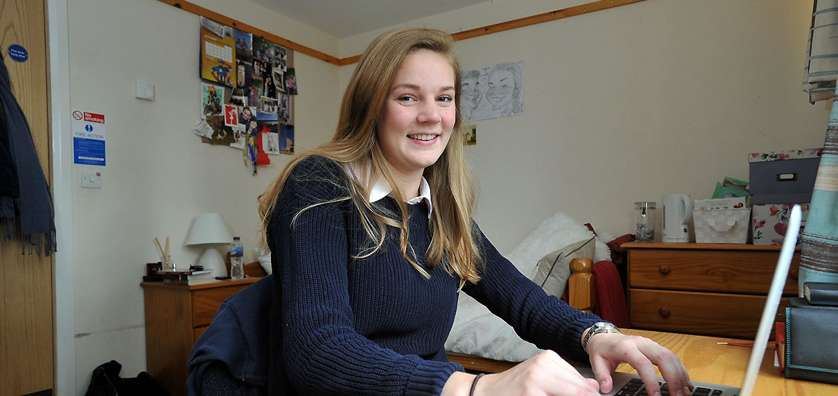 Student sitting at desk in campus hall of residence