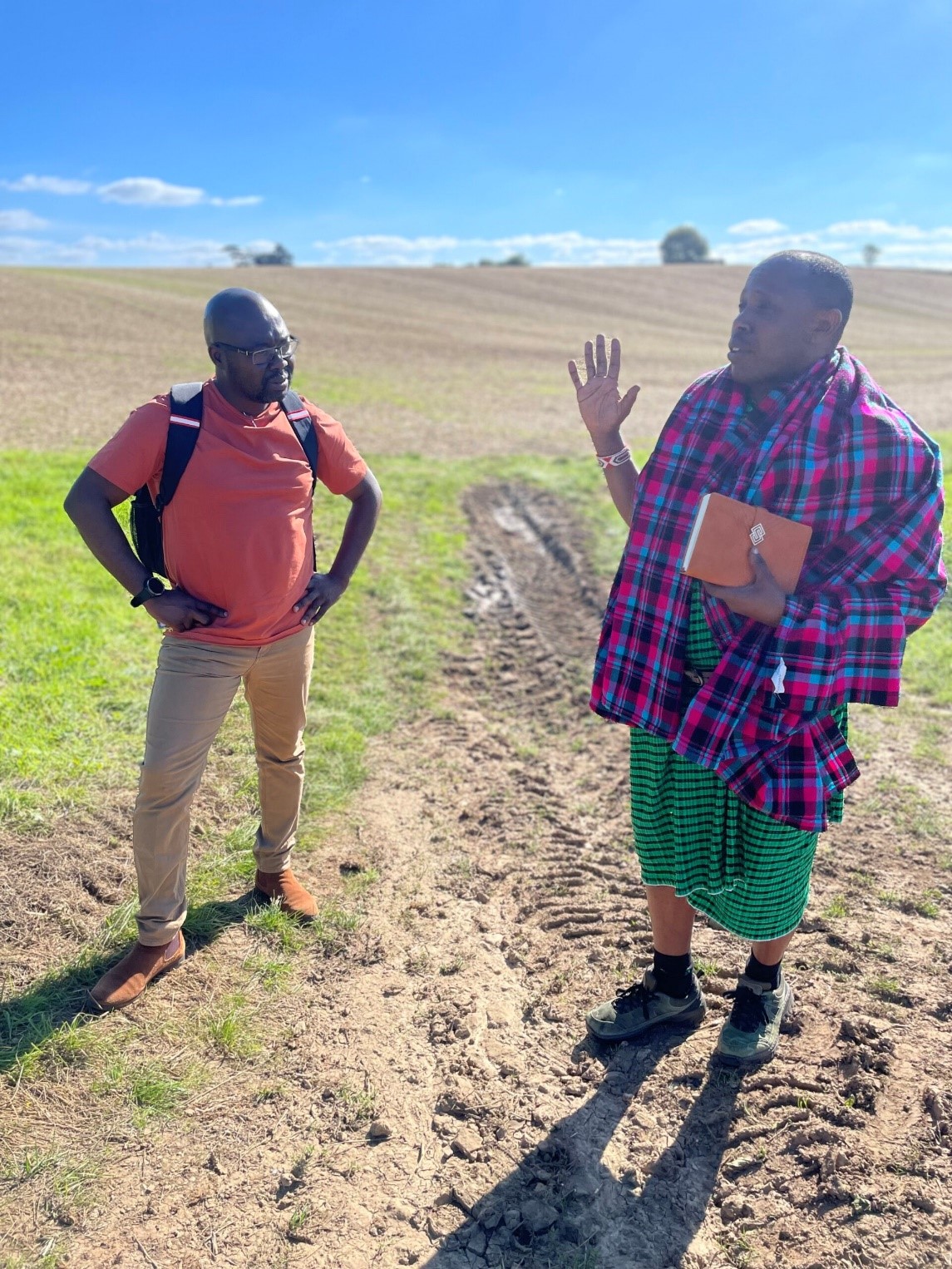 Samwel and Atenchong chatting in a field