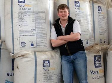 Student leaning against bags of sulphur